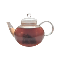 Teekanne aus Glas mit flüssigem Johannisbeere Heidelbeere Hibiskus Früchtetee und losen Früchten