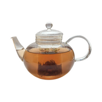 Teekanne aus Glas mit flüssigem Hagebutte Rosmarin Salbei Kräutertee und losem Kräutertee