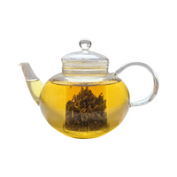Teekanne aus Glas mit flüssigem Salbeitee und losen Salbeiblättern