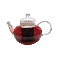 Teekanne aus Glas mit flüssigem Hibiskus Johannisbeere Minze Kräutertee und losem Kräutertee