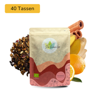 Der Geheimtipp Sonnenkuss Tee Verpackung aus Papier mit losem Orange Ingwer Zimt Früchtetee im Hintergrund