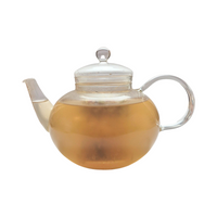 Teekanne aus Glas mit flüssigem Himbeere Vanille Früchtetee und losen Früchten