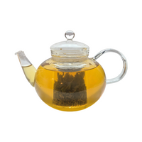 Teekanne aus Glas mit flüssigem Sencha Grüntee und losen Grünteeblättern