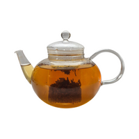 Teekanne aus Glas mit flüssigem Yunnan Schwarztee und losen Schwarzteeblättern