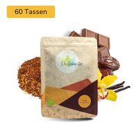 Der Geheimtipp Safari Tee Verpackung aus Papier mit losem Schoko Vanille Rooibos Tee im Hintergrund